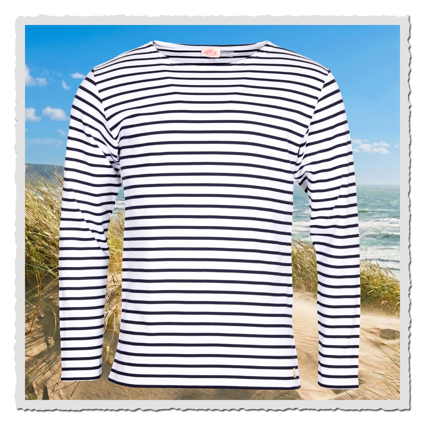 Gestreiftes Armor Lux Herren-Longsleeve in Weiss und Navire mit Heritage-Anker am Saum, frontal fotografiert am Strand.
